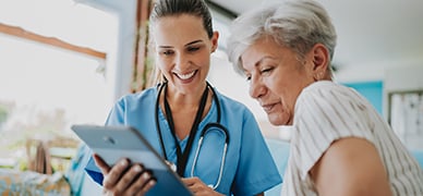 A healthcare professional discussing a senior patients Johnson & Johnson treatment using a tablet.